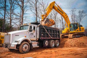 excavator loading dirt into a dump truck